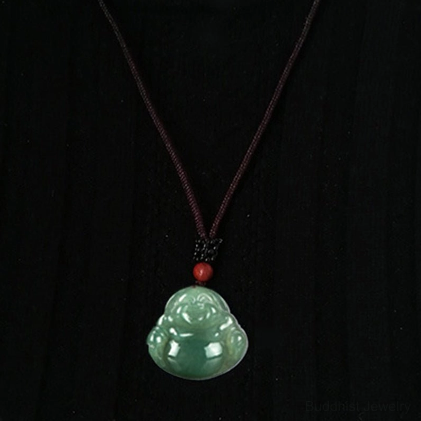 Full length Laughing Buddha jade pendant necklace hanging on dark brown cord against pure black background, complete jewelry display