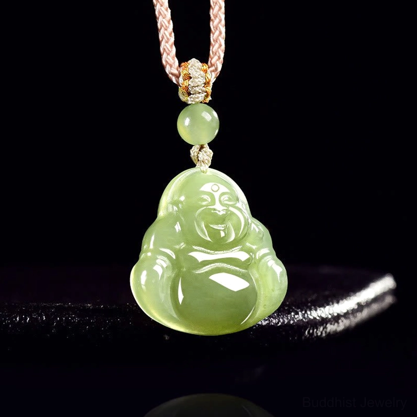 Close-up detail of green jade laughing Buddha pendant showing intricate carving and polished finish with small jade bead accent above the main pendant