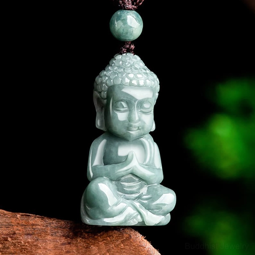 Close-up front view of carved jade Buddha pendant in seated prayer pose, showcasing smooth natural jade texture and intricate Buddhist design