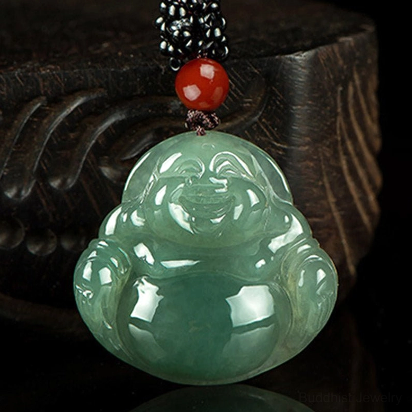 Glossy deep green jade Laughing Buddha pendant necklace with smooth polished surface and dark carved wooden base, detailed close-up view