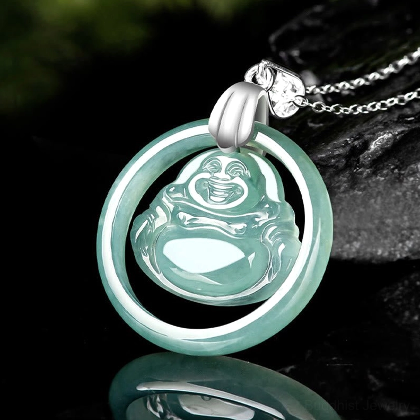 Jade Buddha pendant necklace oblique top view - circular pendant frame with CZ charm clasp on dark rock background