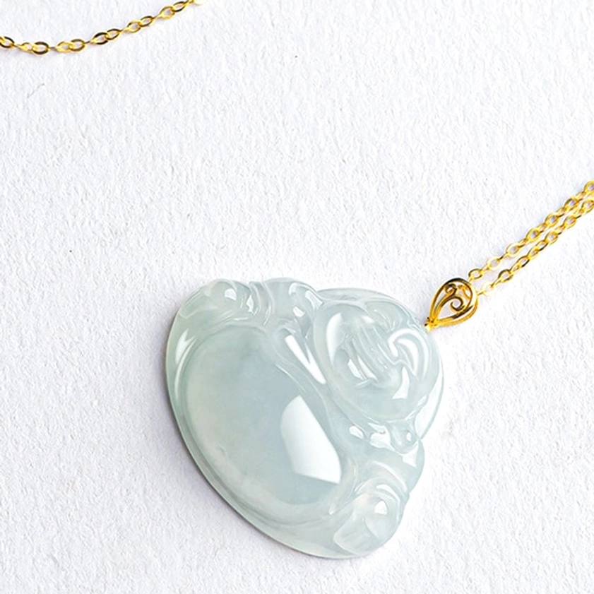 Top-down angled view of carved jade Laughing Buddha pendant showing delicate gold chain and smooth jade texture