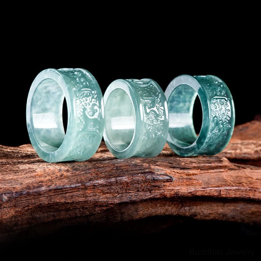 Set of three natural jade Om Mani Padme Hum Buddhist rings in matching light cyan jade, side flat view showing size variety and consistency of hand-carved mantras