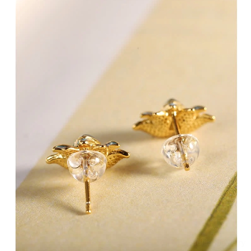 Close-up of jade earring components including gold-plated silver posts and acrylic ear backs