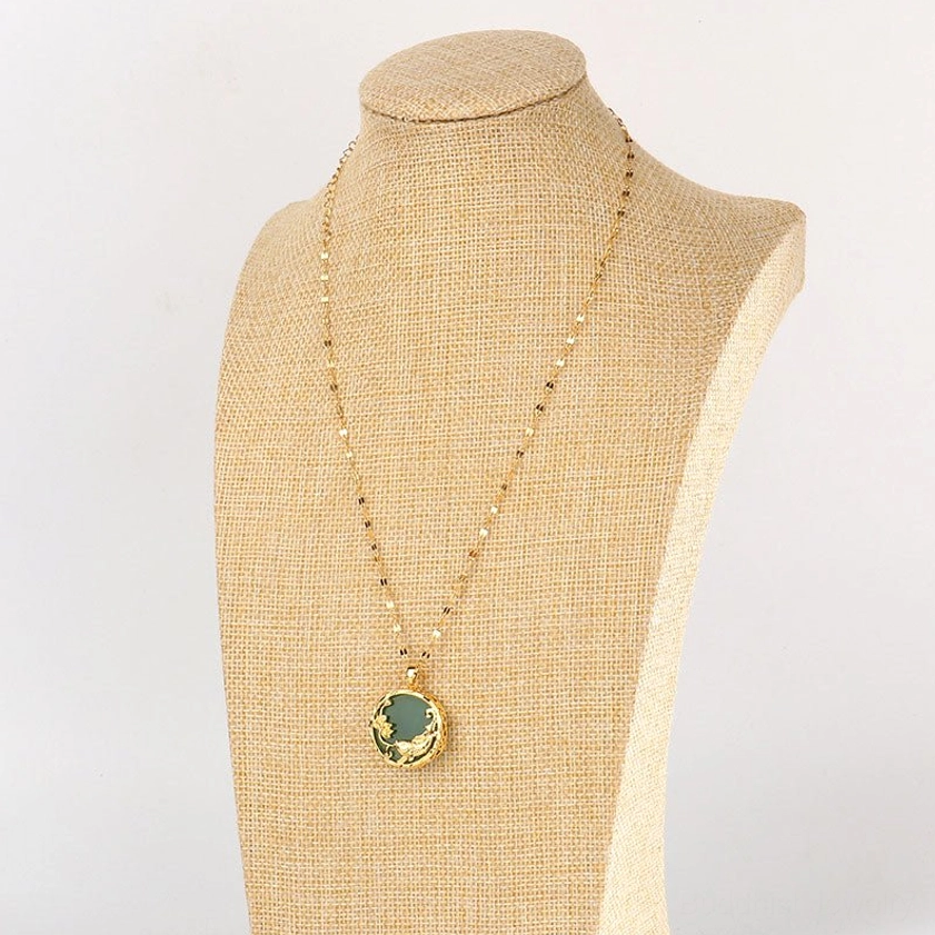 Buddhist jade koi necklace worn on linen jewelry display stand showing front view