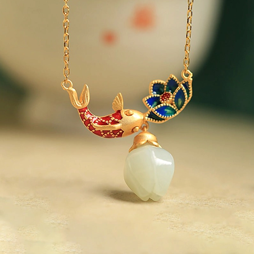 Three-quarter view of handmade koi fish lotus jade necklace showing red and blue enamel accents and matte gold chain