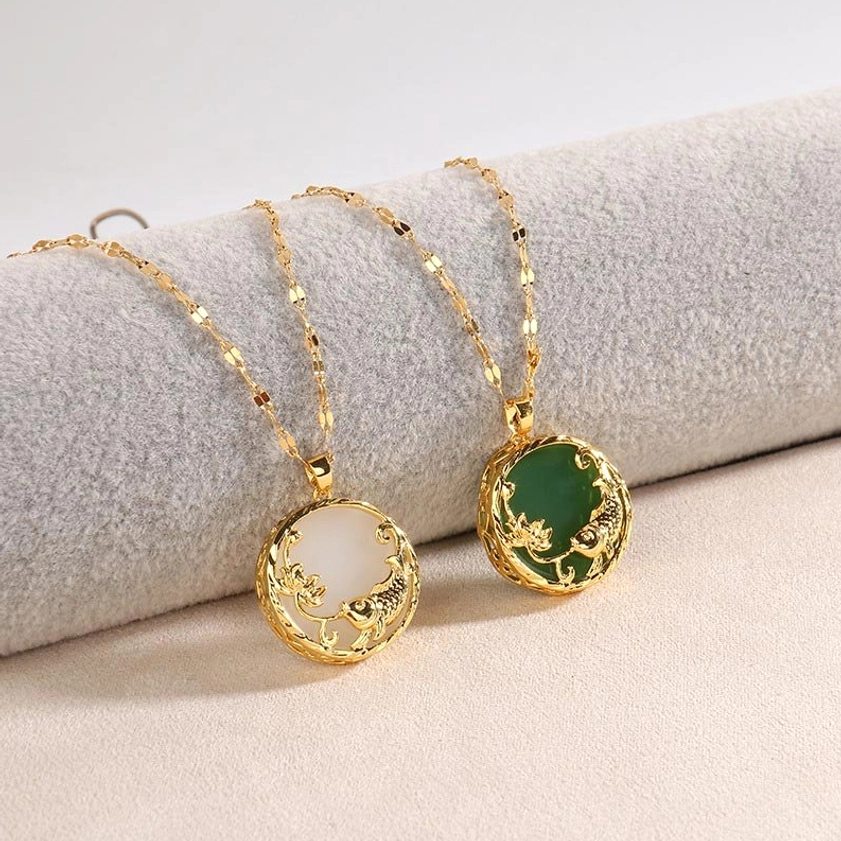 Pair of jade koi necklaces green and white jade with gold details on gray fabric display