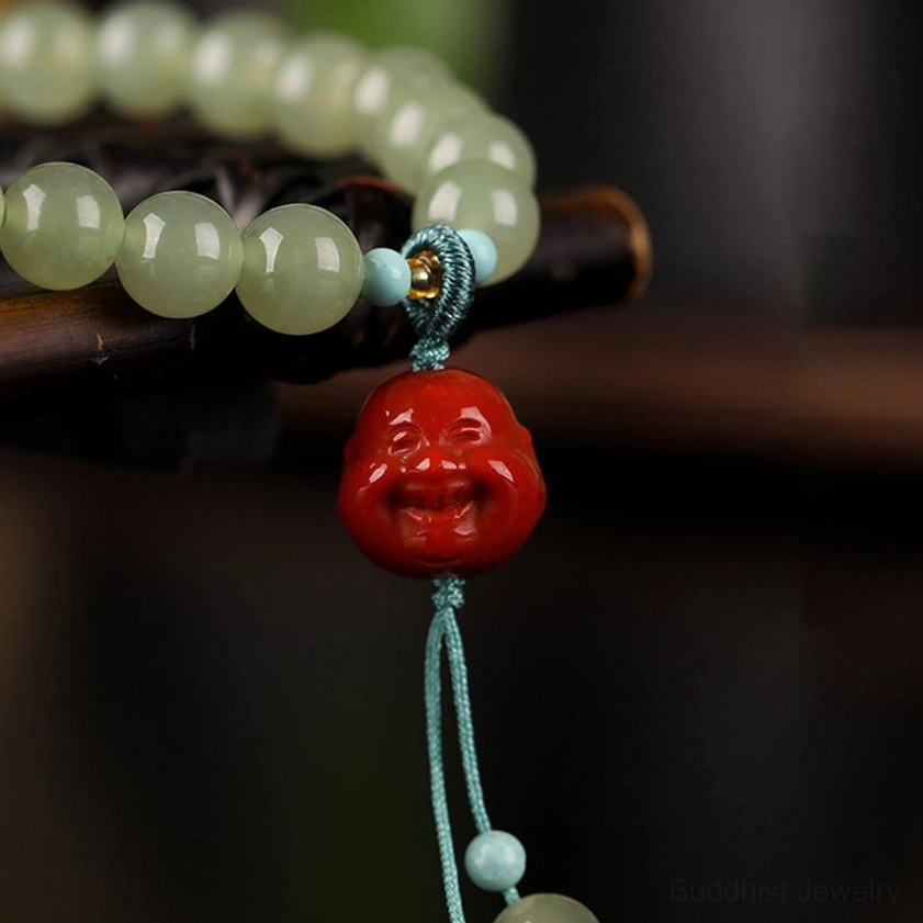 Close-up macro view of polished jade beads with red laughing Buddha pendant and light blue knot connectors