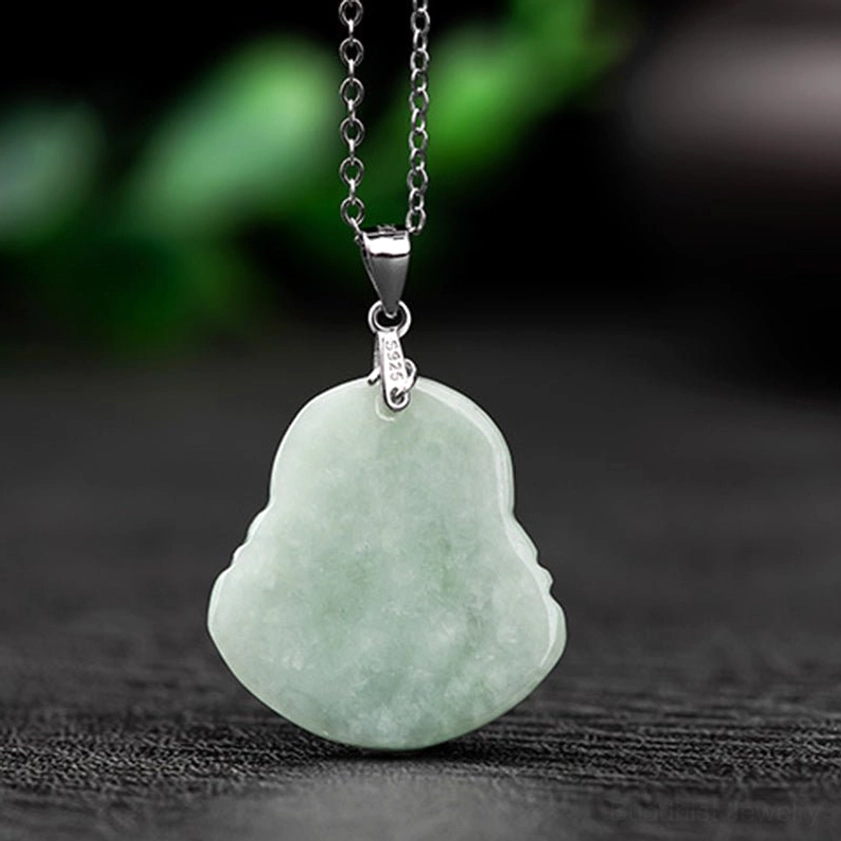 Back view of jade Laughing Buddha pendant necklace showing reverse side of light green jade carving with silver clasp on dark background