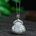Natural jade Laughing Buddha pendant necklace front view with silver crystal frame and green gem bail