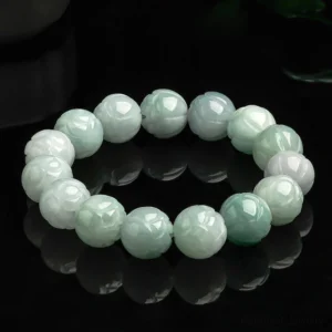 Natural jade lotus carving prosperity bracelet with carved lotus beads in light green and white jade tones on reflective black background