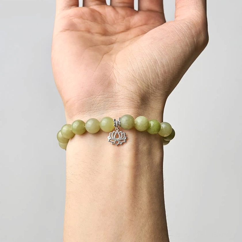 Cyan jade luck bracelet worn on human wrist showing natural fit and size with silver lotus pendant visible