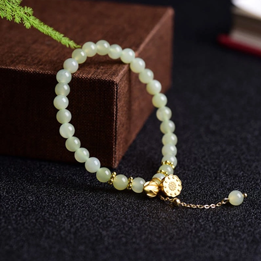 Hetian jade lotus bracelet in wooden box, side oblique view with gold lotus charm detail
