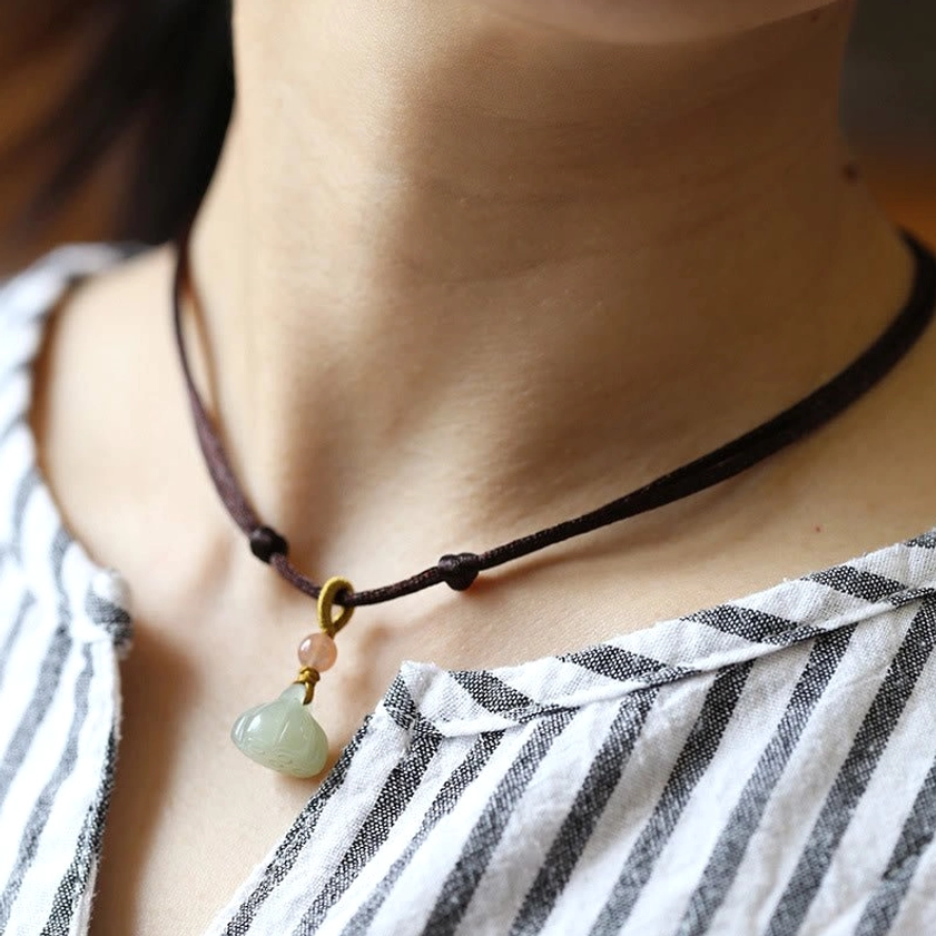 Brown cord jade lotus necklace variant with carved green lotus pendant for Buddhist meditation