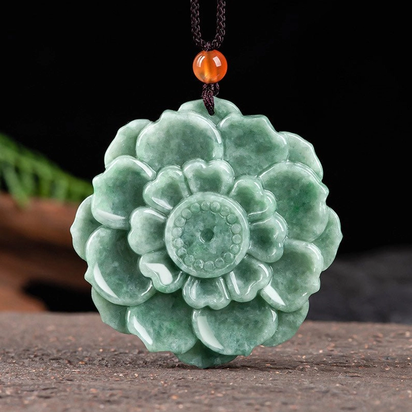 Hand-carved natural green jade lotus pendant necklace with brown cord and orange bead accent, Buddhist prosperity symbol
