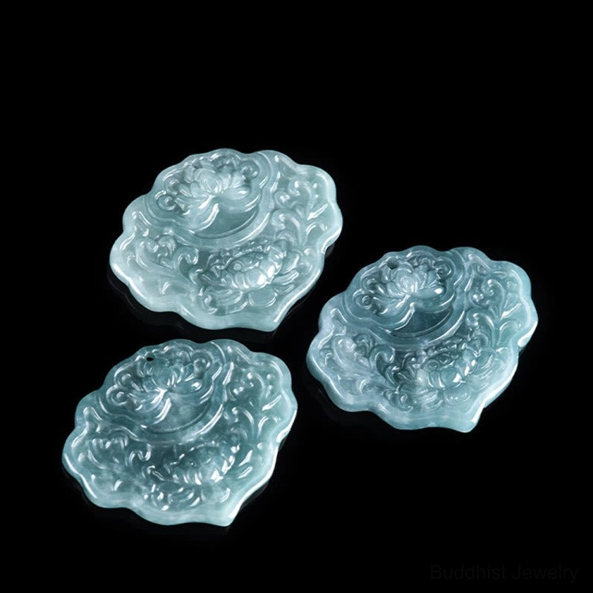 Multiple loose jade lotus pendants displayed as flat lay, three identical bluish-green carved stones showing consistent quality and hand-carved craftsmanship