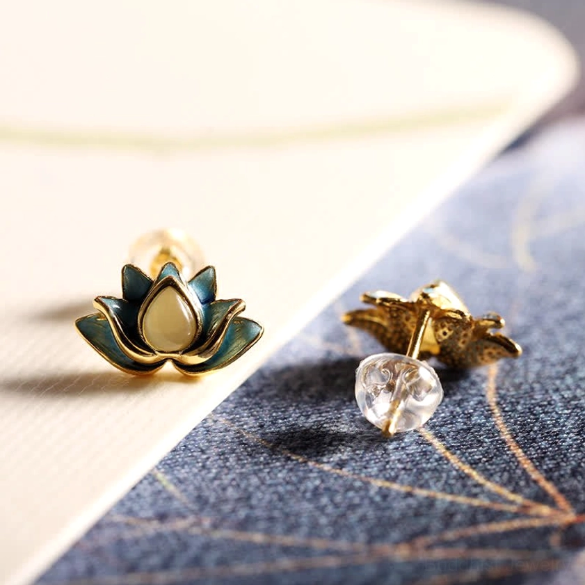 Cyan jade lotus earrings with clear acrylic ear backs and silver posts displayed at oblique angle