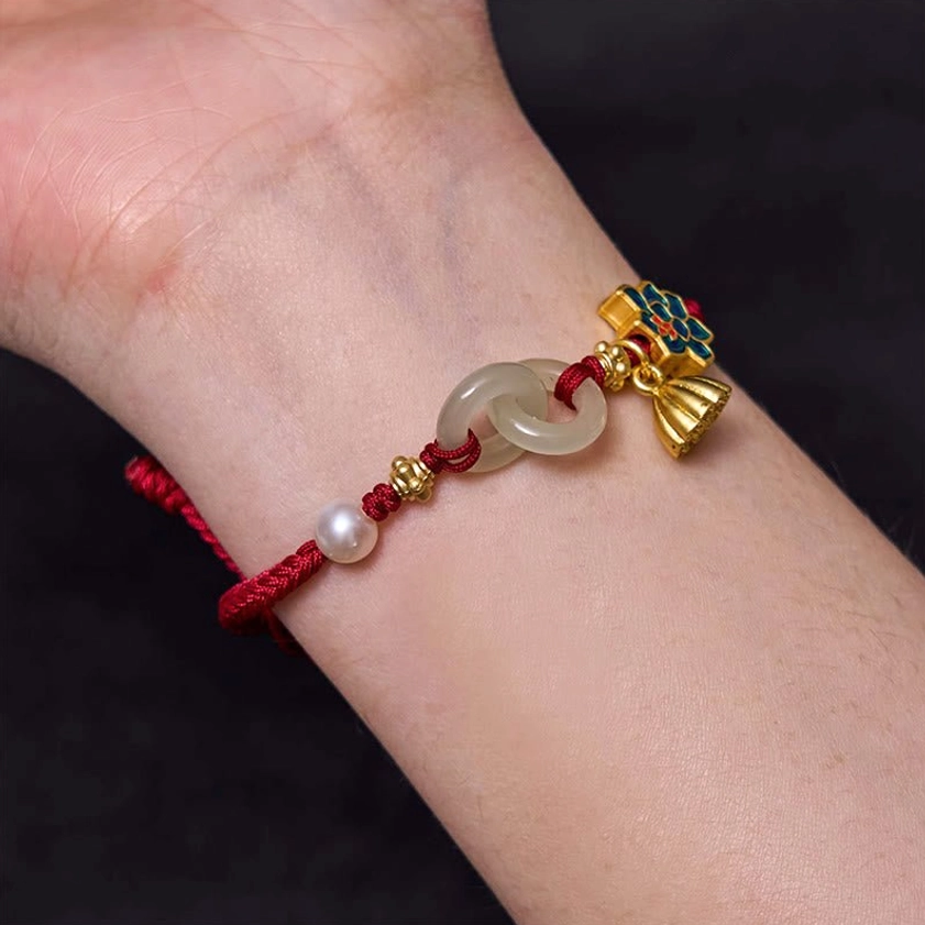 Worn on wrist showing how Hetian jade peace buckle bracelet looks in daily wear with red cord and lotus charms
