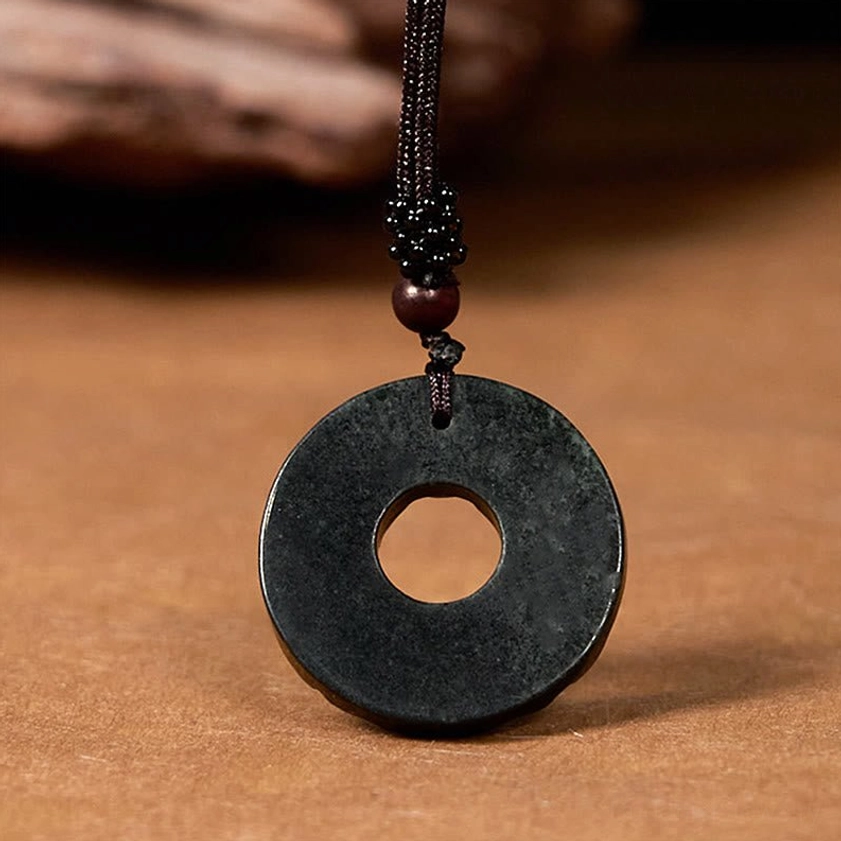 Plain black-green jade peace buckle with matte natural finish and dark braided necklace cord