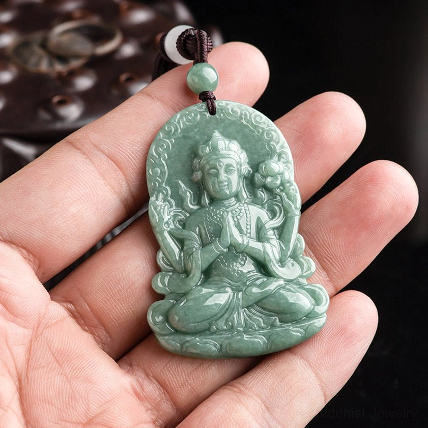 Four-armed Avalokitesvara jade pendant held in hand showing size and craftsmanship