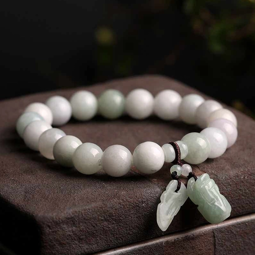 Authentic jade Buddhist bracelet with mottled light and off-white beads, jade Pi Xiu and leaf pendants on dark fabric display base