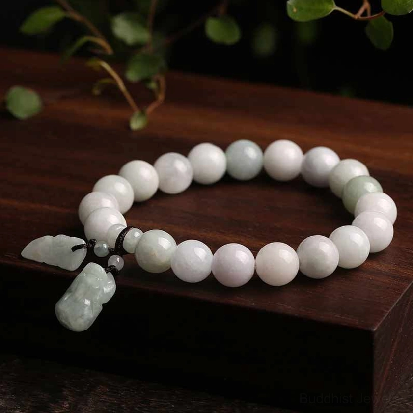 Handcrafted jade prosperity bracelet with pale pink and light green jade beads, dark brown cord fastening, and jade Pi Xiu pendant on wooden display stand