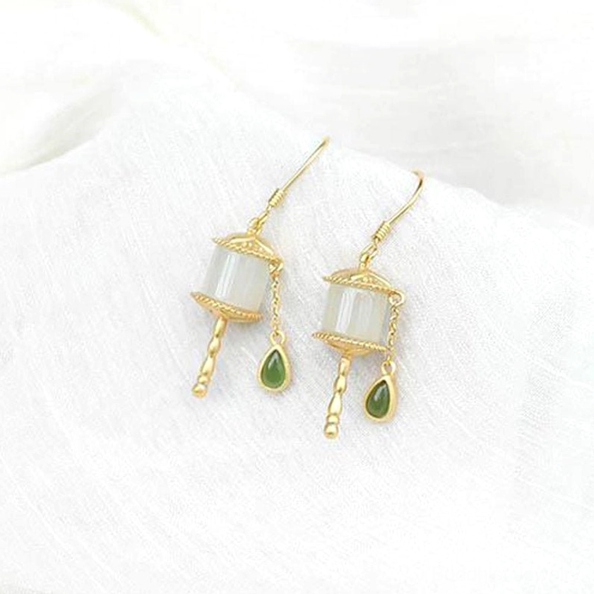 925 sterling silver jade prayer wheel dangle earrings flat lay on white linen fabric, elegant minimalist design with dark green jade