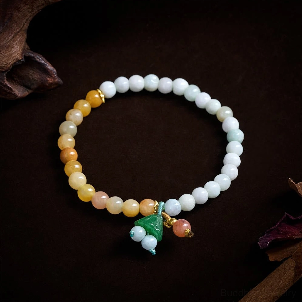 Circular arrangement of jade and quartzite beads with lotus pod charm detail on dark brown background