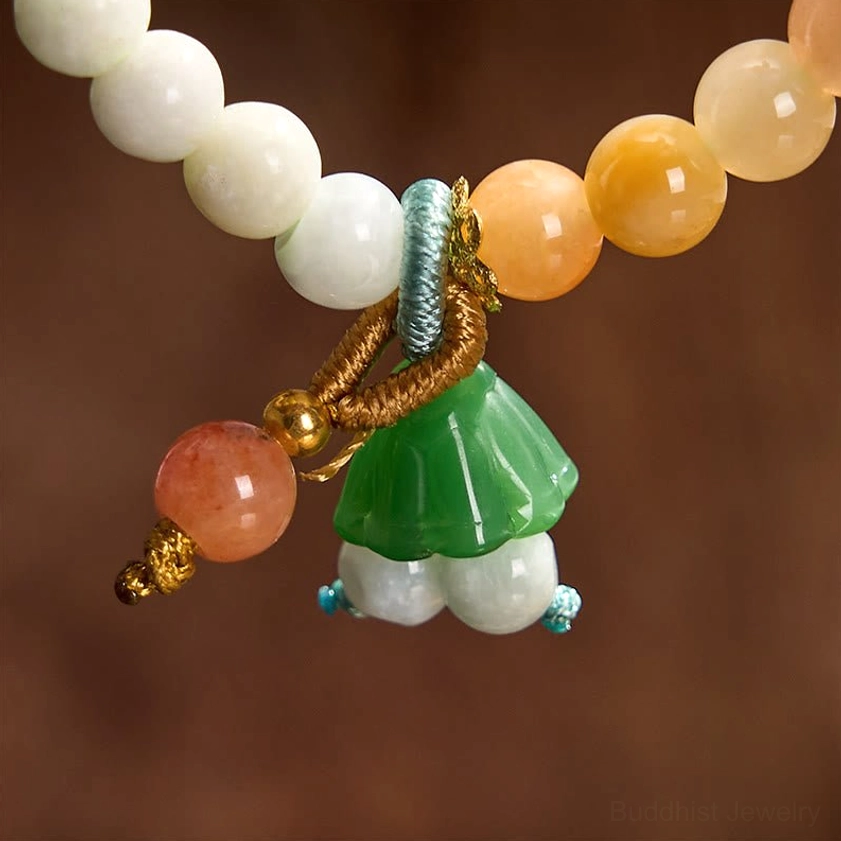 Close-up extreme detail shot of jade and quartzite beads, braided knots, and lotus pod peace buckle charm design