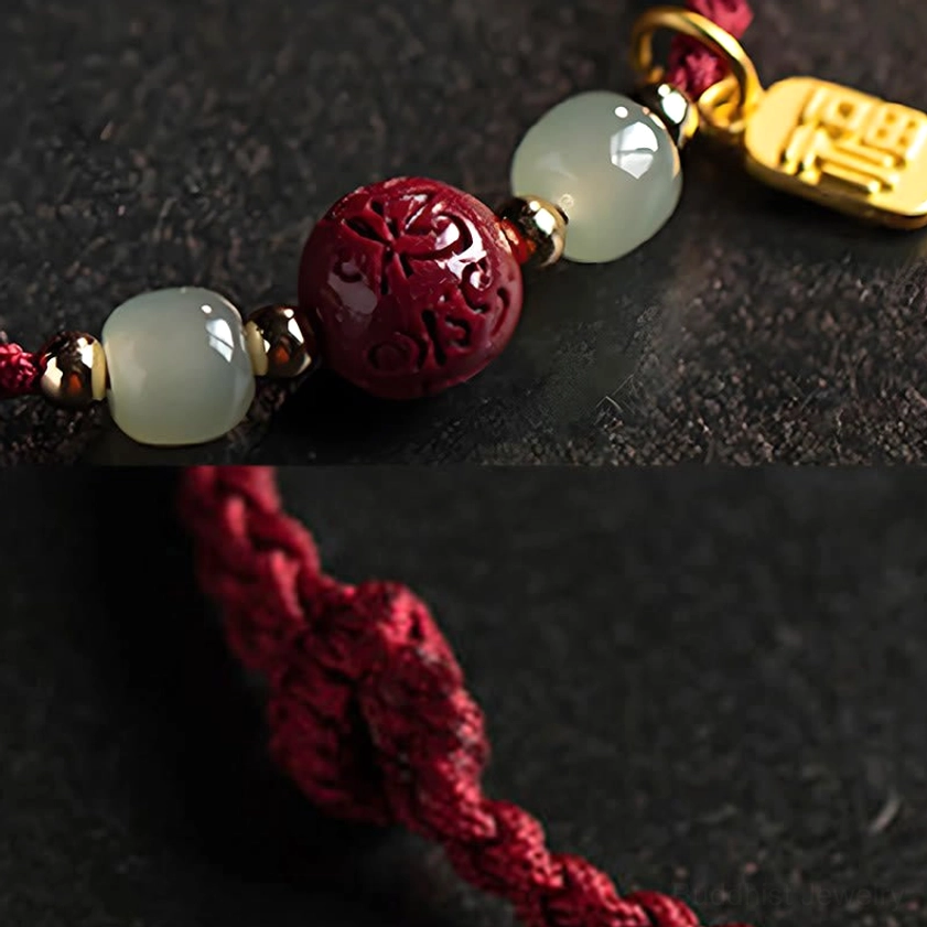 Macro detail of red string bracelet with jade beads metal spacers and Fu character gold pendant