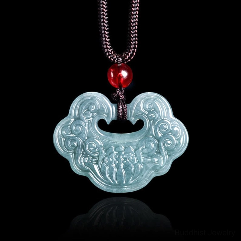 Hand-carved jade Ruyi Buddhist pendant front view flat lay on black background showing intricate lotus pattern
