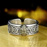 Yellow Jambhala Buddhist copper ring front view showing embossed deity relief and ancient coin engravings