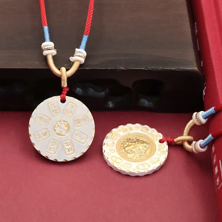 Pair of Yellow Jambhala pendants from side view showing intricate engraved religious patterns and Buddhist text on both sides
