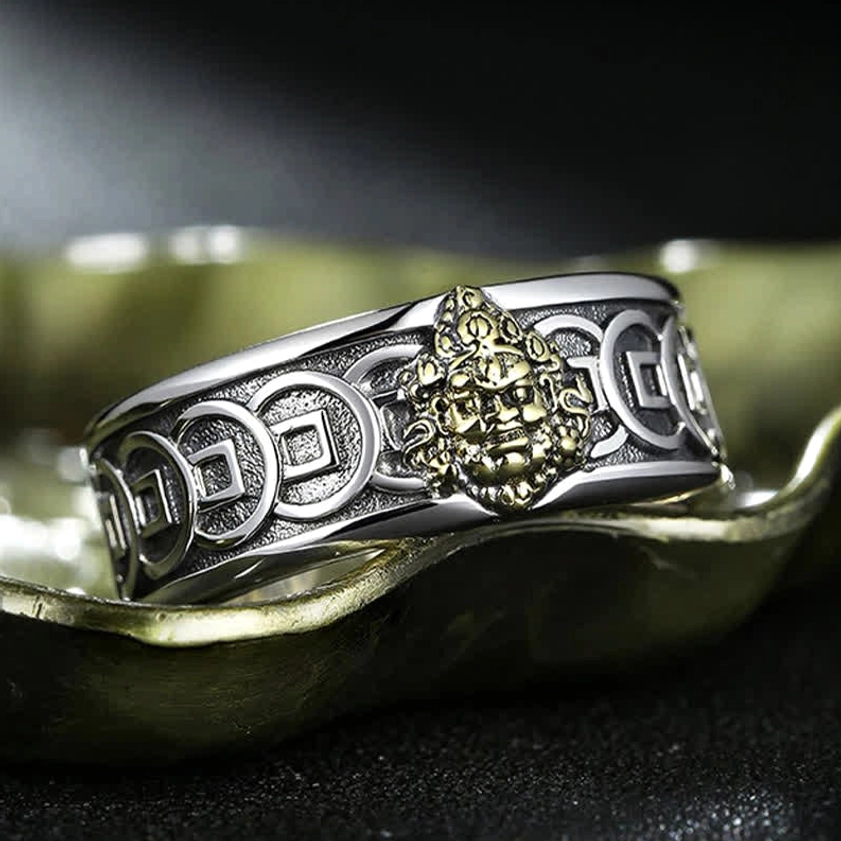 High angle view of Jambhala Buddhist ring showing raised brass relief deity and detailed ancient coin engravings