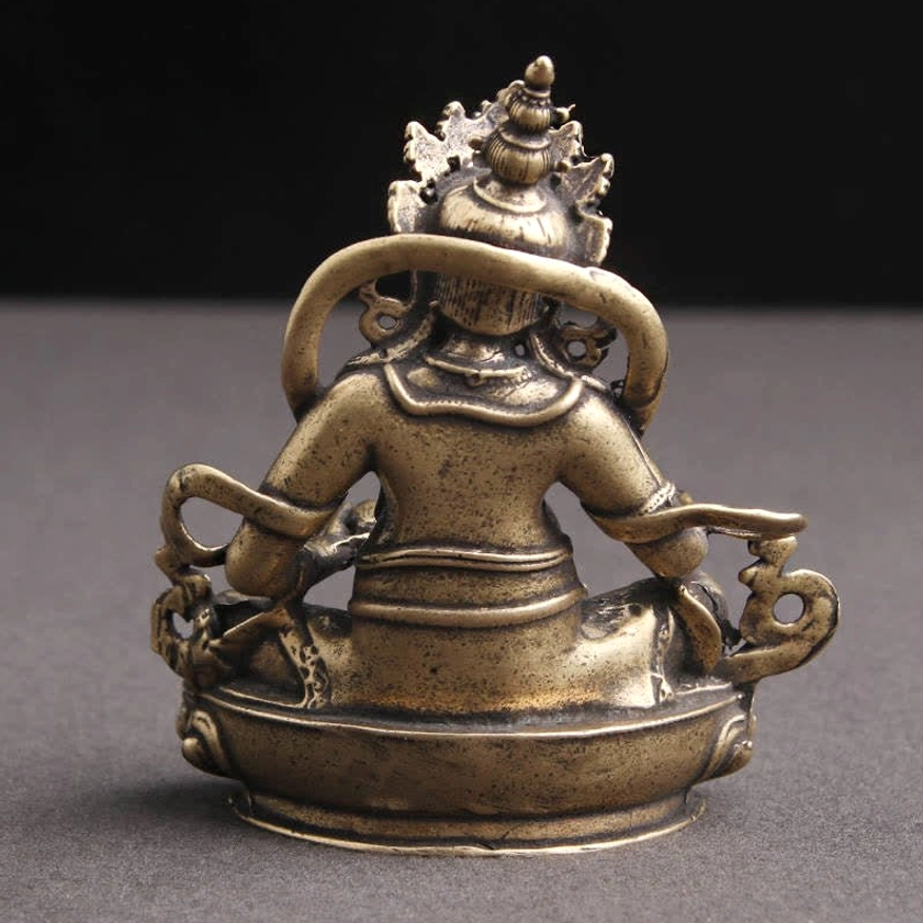 Yellow Jambhala Buddha statue rear view displaying back decorative structure and hollow lotus pedestal base