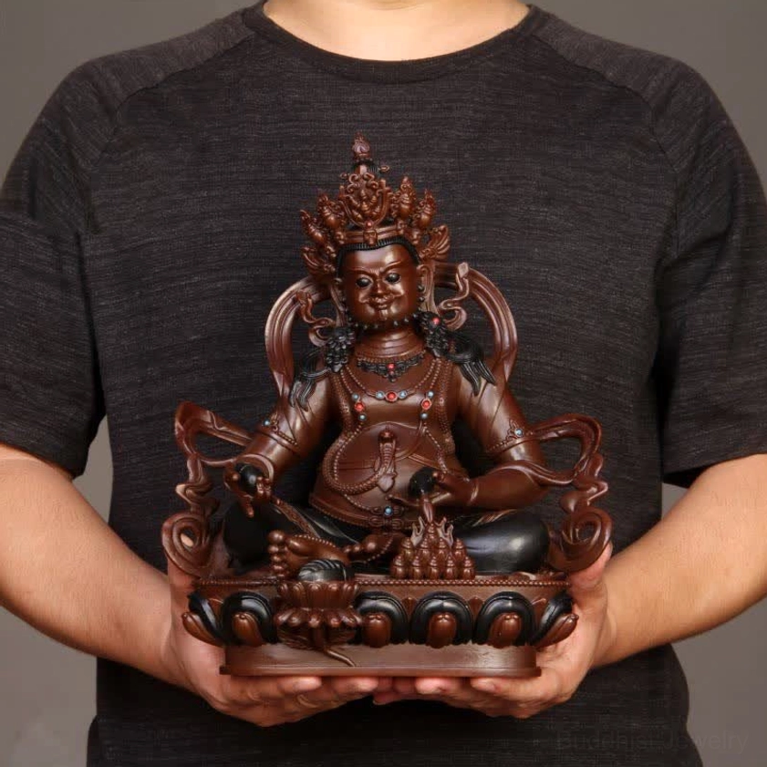 Hand-held size comparison of Yellow Jambhala copper statue showing actual dimensions