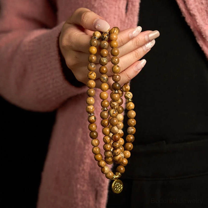 Hand-held picture jasper Buddhist prayer mala with gold lotus pendant draped view