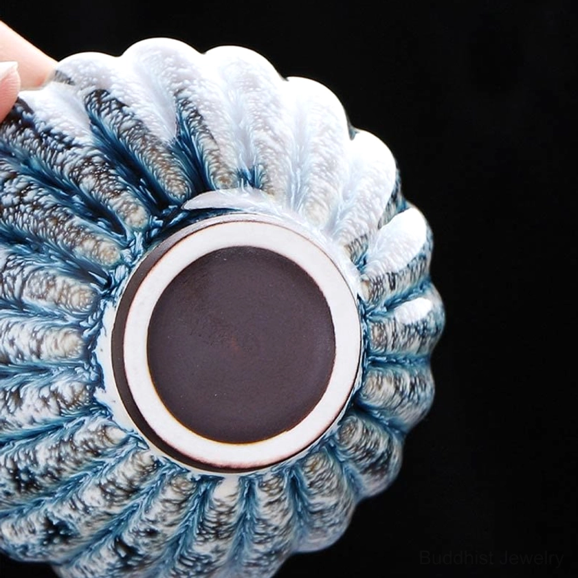 Bottom view of jian zhan lotus tea cup showing dark footed base and white rim border