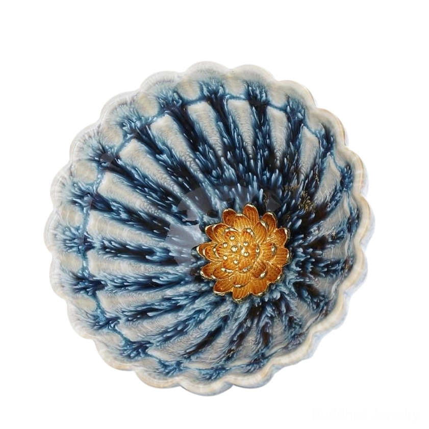 Close up top view of lotus jian zhan teacup with scalloped rim and central gold floral inlay