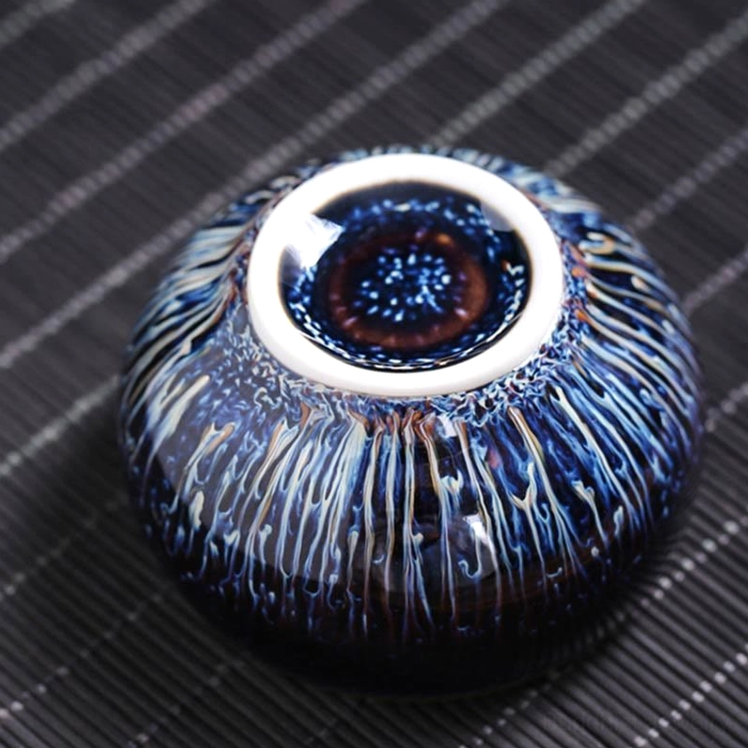 Jian Zhan ceramic cup base and interior close-up, displaying brown bottom and white inner rim with streaked blue-white kiln glaze