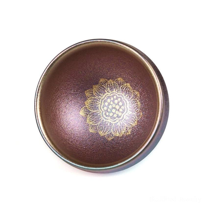 Authentic Jianzhan ceramic teacup with glossy golden lotus design and iridescent reddish-brown interior - angled top-down presentation