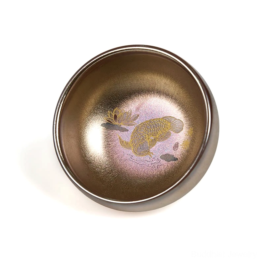 Handmade Jianzhan cup with gradient bronze-gold glaze and koi lotus printed decor, oblique overhead view white background