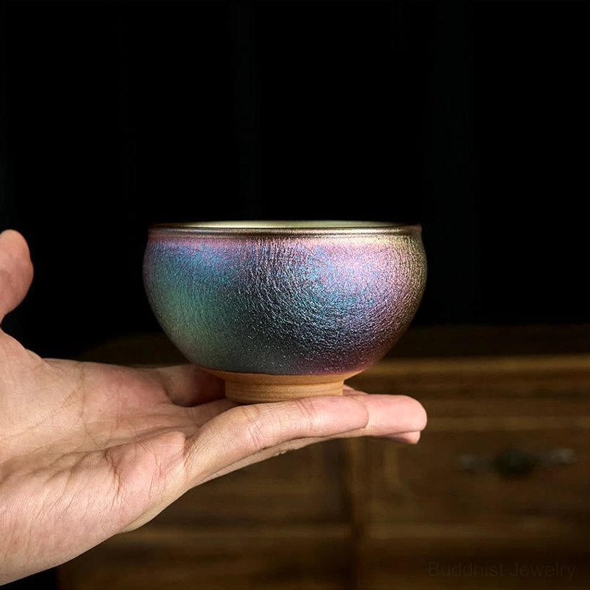 Jianzhan Buddhist tea cup with iridescent blue-purple to bronze gradient glaze and unglazed clay foot ring - side profile view