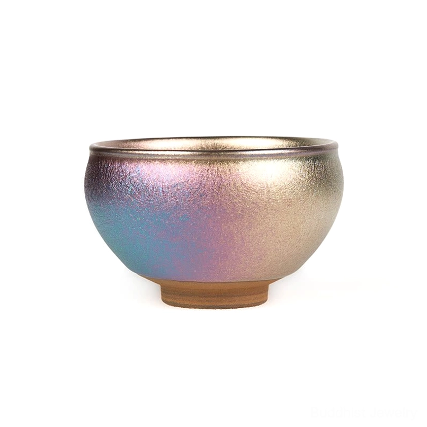 Handcrafted Jianzhan tea cup with iridescent metallic finish, blue-purple to bronze glaze, and unglazed foot - side profile on white background