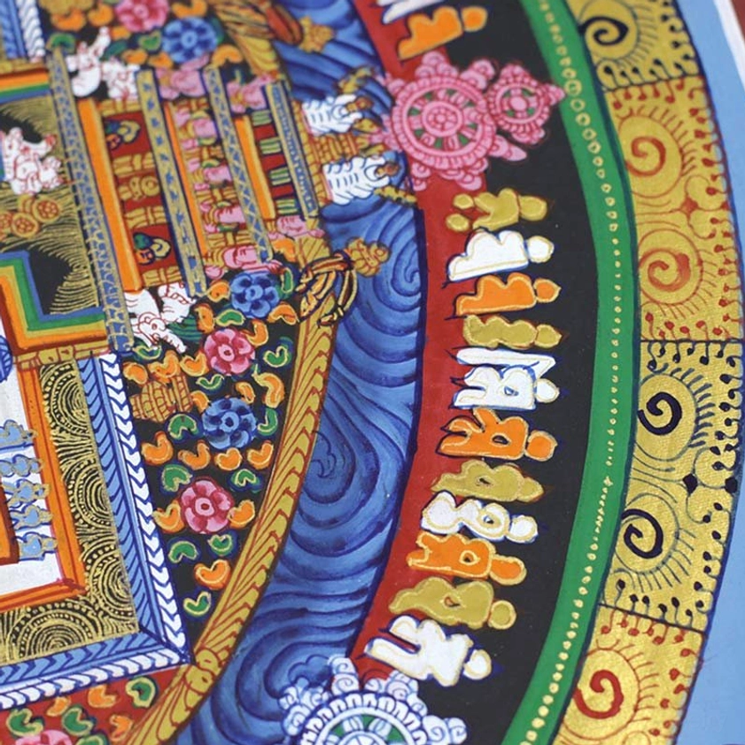 Extreme close-up of Kalachakra Mandala Thangka showing Tibetan script, Dharma wheel motif, and gold scrollwork spiritual details