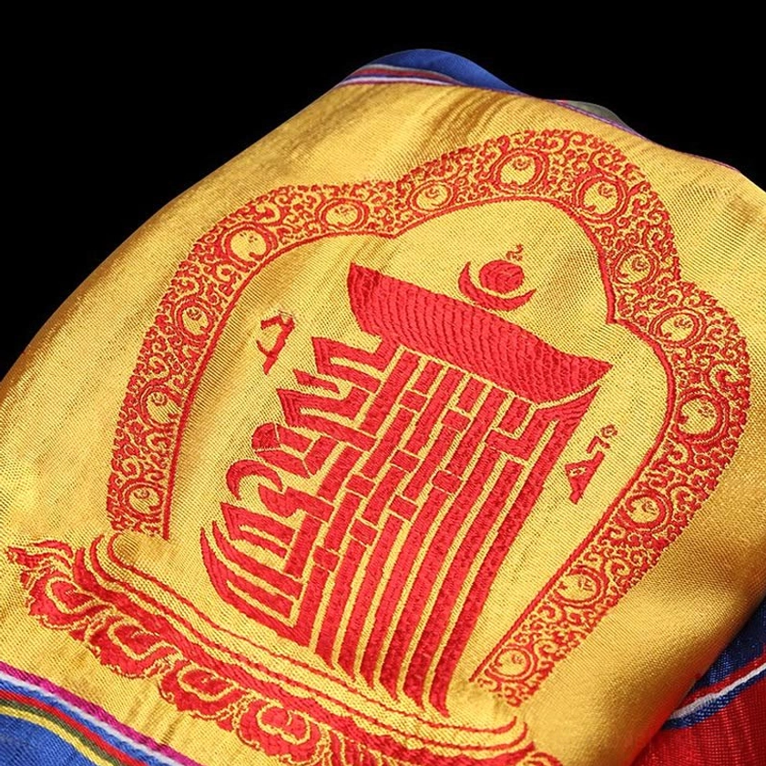 Section of sacred Buddhist Khata with red seal embroidery, ornate red border, and golden-yellow base fabric