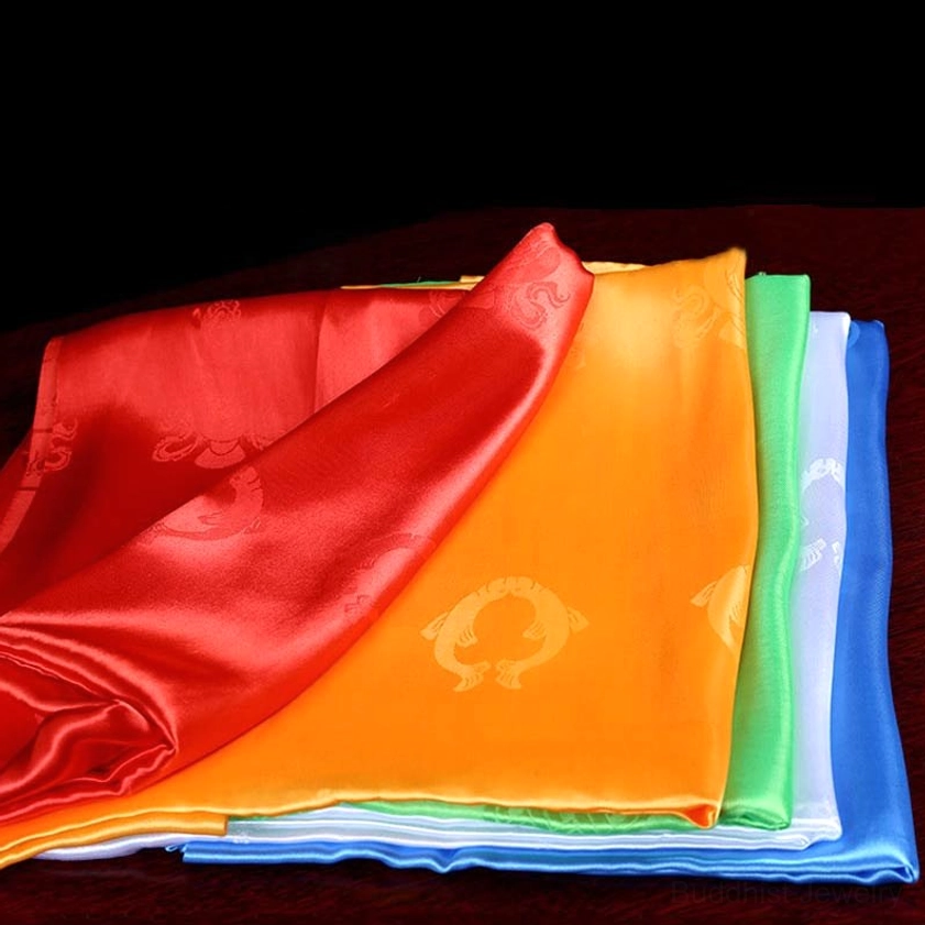 Tibetan khata blessing scarves mixed display oblique side view showing satin texture and circular embossed religious designs