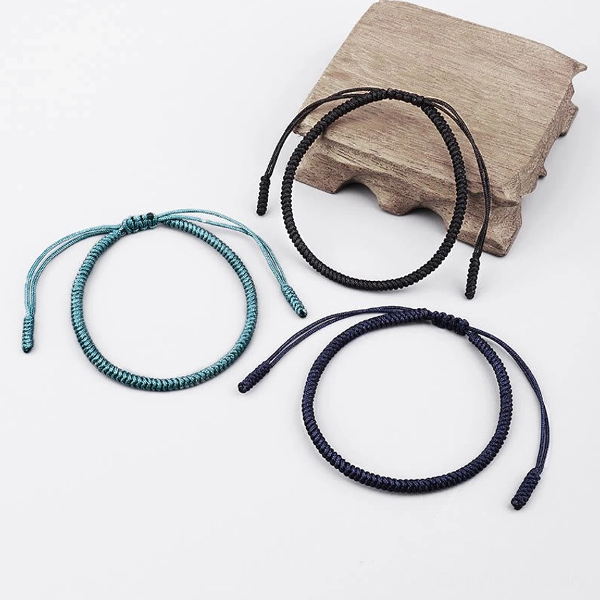 Three individual Buddhist King Kong knot bracelets displayed on wooden base - adjustable protection amulet set