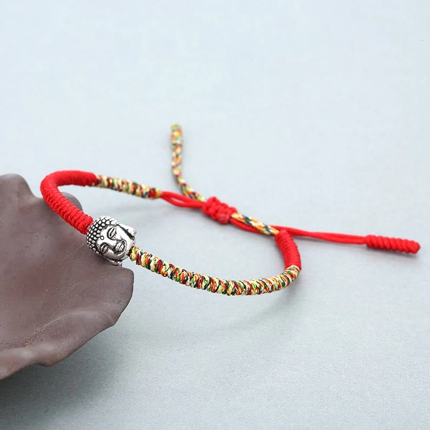 Lucky Buddhist string bracelet with adjustable drawstring and silver Buddha head charm, side angle detail shot