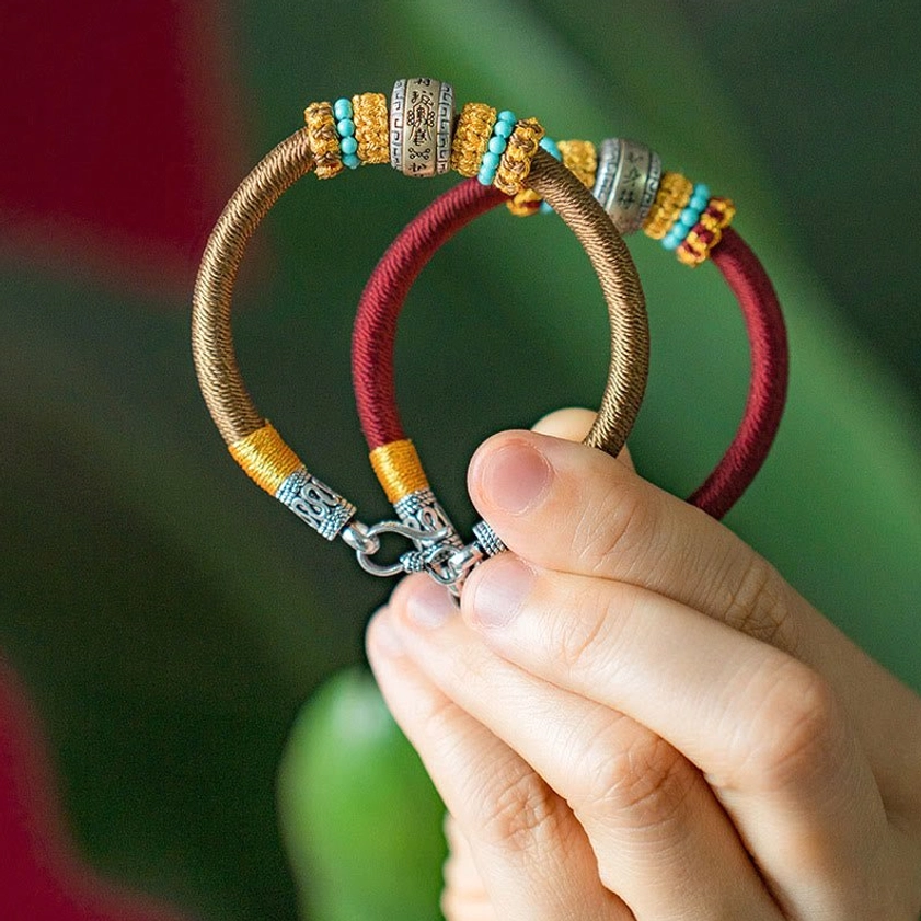 Handmade Buddhist King Kong Knot bracelet close-up detail of engraved metal charm with semi-precious beads